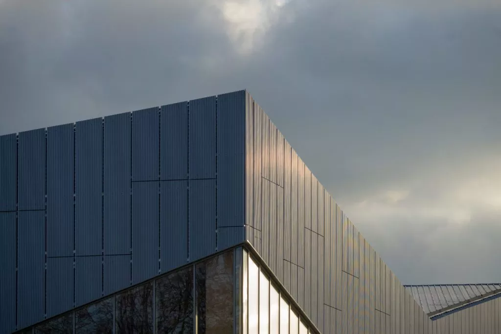 Gros plan d’un bardage moderne de couleur grise réalisé par le groupe H2RA du Complexe sportif Léo Lagrange à Val de Reuil.