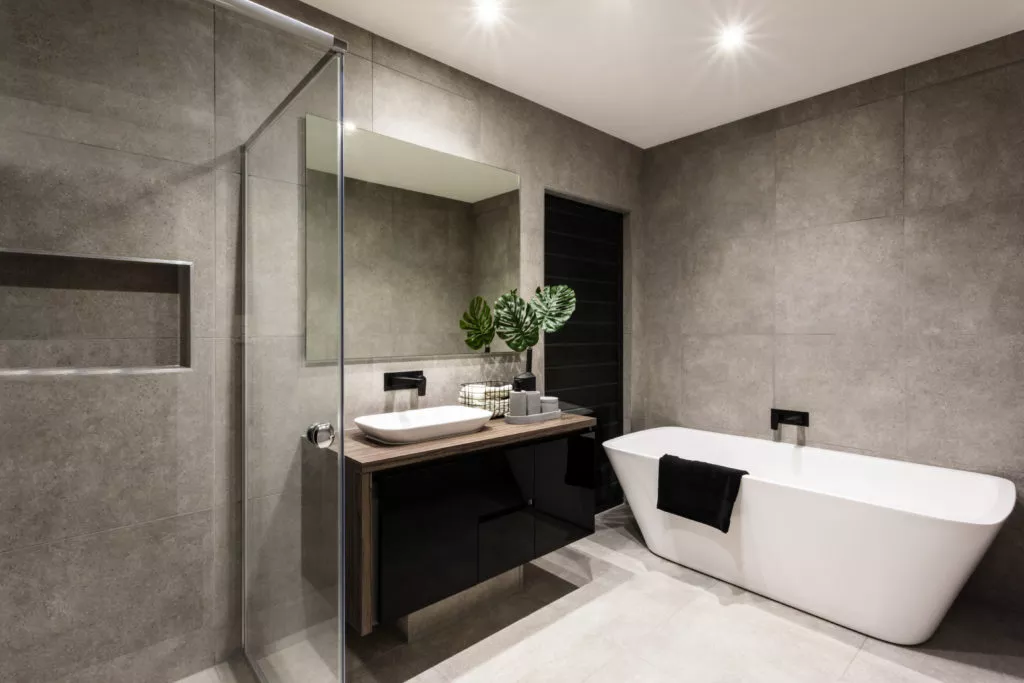 Plomberie Leblanc (groupe H2RA) : salle de bain moderne avec baignoire îlot, douche vitrée et meuble vasque, installation sanitaire liée au chauffage et à la ventilation.